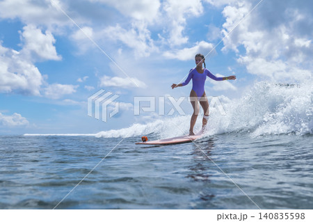 Young Surfer Balancing Gracefully Under Ominous Clouds In Ocean Young Surfer Balancing Gracefully Under Ominous Clouds In Ocean 140835598