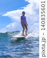 Teenage Girl Skillfully Balancing On Wave During Serene Coastal Surfing Session 140835601