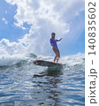 Cheerful Young Lady Balances On surfboard Amid Stormy Skies And Powerful Seas 140835602