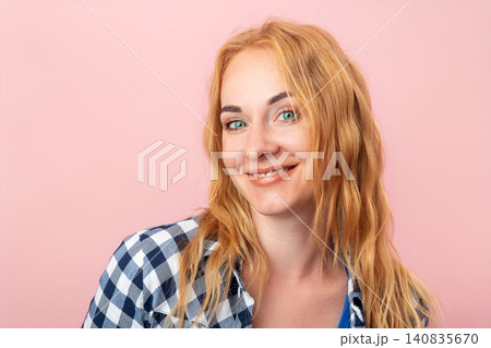 Young woman with long wavy blonde hair capturing confidence and happiness, smiling and looking directly at the viewer, showing a friendly and positive expression Young woman with long wavy blonde hair capturing confidence and happiness, smiling and looking directly at the viewer, showing a friendly and positive expression 140835670