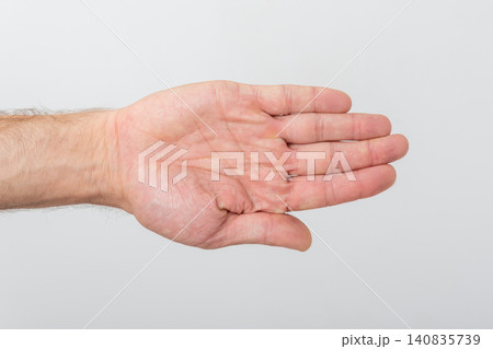 Person's hand displaying an open palm, fingers extended horizontally on a neutral background, conveying concepts of stopping, presenting, and open communication Person's hand displaying an open palm, fingers extended horizontally on a neutral background, conveying concepts of stopping, presenting, and open communication 140835739