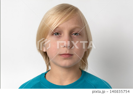 Young blonde boy with a neutral expression looking directly at the viewer, presenting a calm and simple portrait with copy space on a clean white background Young blonde boy with a neutral expression looking directly at the viewer, presenting a calm and simple portrait with copy space on a clean white background 140835754