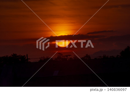 Golden big sun setting down on the horizon during a dramatic sunset. 140836097