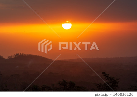 Golden big sun setting down on the horizon during a dramatic sunset. 140836126