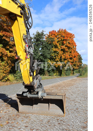 Yellow excavator boom against a backdrop of autumn trees. Yellow excavator boom against a backdrop of autumn trees. 140836526