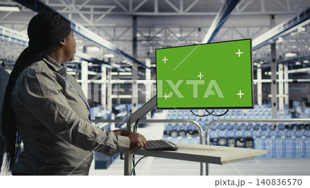 African American software developer uses a chroma key workstation in a server hub to scan equipment issues and perform backups. African American software developer uses a chroma key workstation in a server hub to scan equipment issues and perform backups. 140836570