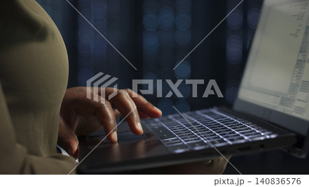 System administrator uses a laptop in a server room to review test results and confirm reliable system operation. System administrator uses a laptop in a server room to review test results and confirm reliable system operation. 140836576