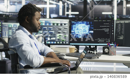 Data center specialist in wheelchair uses node tree AI software to analyze infrastructure and identify issues in a data center. Data center specialist in wheelchair uses node tree AI software to analyze infrastructure and identify issues in a data center. 140836589