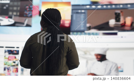 African American woman watches a video wall, enjoying digital lifestyle content, social media technology and global online connection. African American woman watches a video wall, enjoying digital lifestyle content, social media technology and global online connection. 140836604