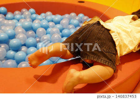 屋内プレイルームの青いボールプールで遊ぶ1歳児。 140837453