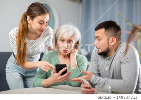Adult children help an elderly mother learn how to use smartphone Adult children help an elderly mother learn how to use smartphone 140837813