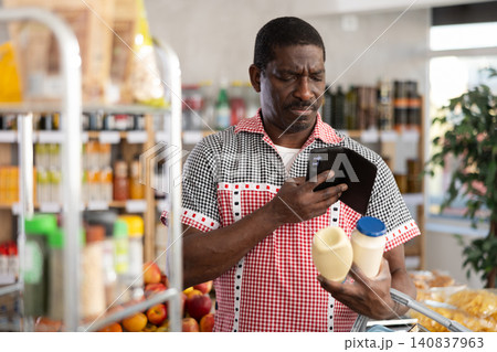 African male client scans QR code on mayonnaise package African male client scans QR code on mayonnaise package 140837963