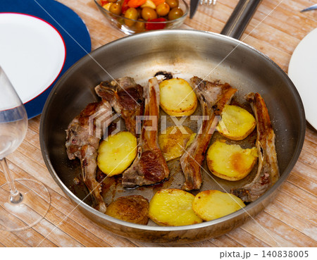 Seared and roasted lamb ribs served with baked potato on table, top view. Seared and roasted lamb ribs served with baked potato on table, top view. 140838005