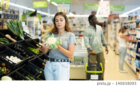 Portrait of woman buying fresh cauliflower in grocery shop Portrait of woman buying fresh cauliflower in grocery shop 140838093