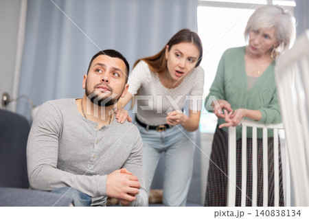 Man ignoring two women arguing at home Man ignoring two women arguing at home 140838134