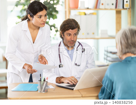 Male and female doctors explaining diagnostic results to elderly patient Male and female doctors explaining diagnostic results to elderly patient 140838250