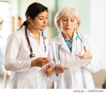 Two female doctors discussing medical test results in clinic Two female doctors discussing medical test results in clinic 140838289