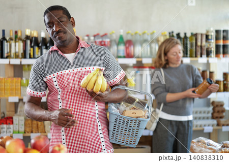 Male shopper carefully selects the freshest bananas in supermarket Male shopper carefully selects the freshest bananas in supermarket 140838310