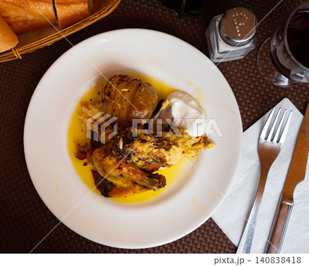 Roasted chicken breast with wing served with skinned baked potato Roasted chicken breast with wing served with skinned baked potato 140838418