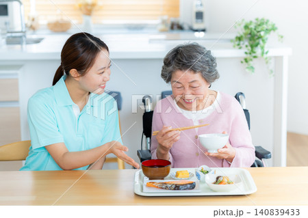 食事の介助をするヘルパーとシニア女性 140839433
