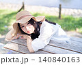 公園のテーブルでくつろぐ若い女性 140840163