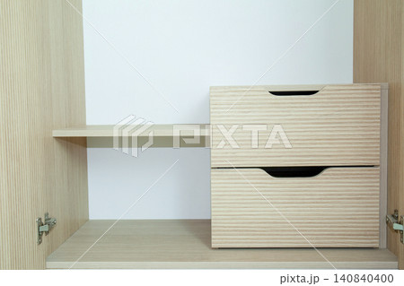 Sleek wooden shelving unit features clean lines and functional drawers Sleek wooden shelving unit features clean lines and functional drawers 140840400