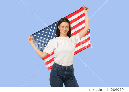 Young woman holds American flag proudly. Spirit of travel and cultural connection concept Young woman holds American flag proudly. Spirit of travel and cultural connection concept 140840404