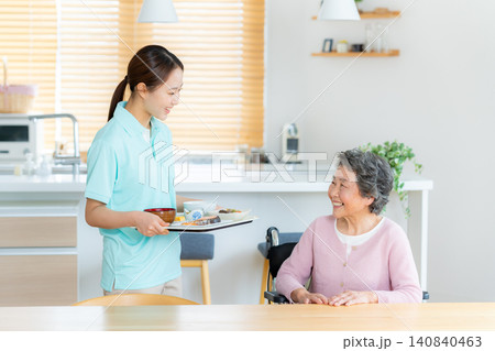 食事の介助をするヘルパーとシニア女性 食事の介助をするヘルパーとシニア女性 140840463