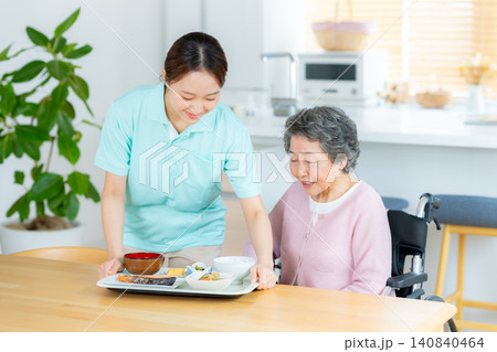 食事の介助をするヘルパーとシニア女性 食事の介助をするヘルパーとシニア女性 140840464
