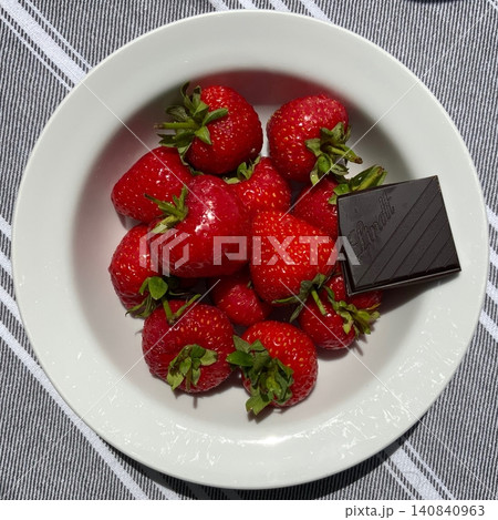 Fresh strawberries paired with rich chocolate bars create a vibrant and tempting contrast. Bright red fruit and smooth cocoa make a naturally irresistible duo. 140840963