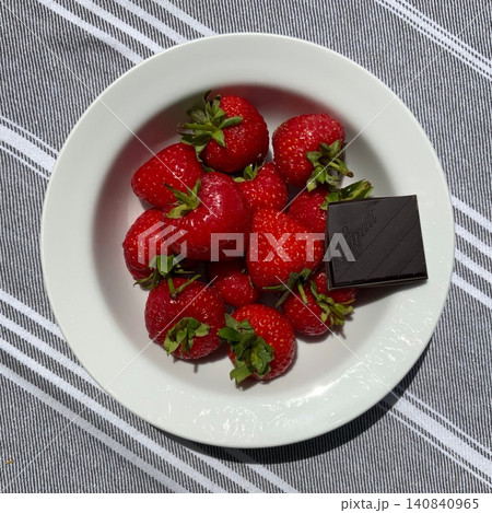 Fresh strawberries paired with rich chocolate bars create a vibrant and tempting contrast. Bright red fruit and smooth cocoa make a naturally irresistible duo. 140840965
