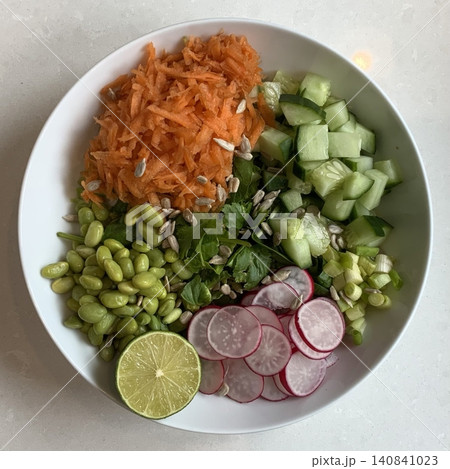 Fresh salad with a mix of crisp leafy greens, sliced vegetables, and colorful ingredients, tossed together to create a healthy, vibrant, and refreshing dish full of natural flavors 140841023