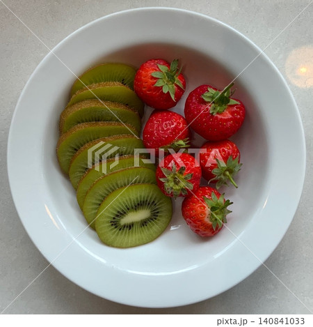 Fresh strawberries and kiwi create a vibrant mix of red and green with juicy sweetness and a zesty tang. Their bright colors and refreshing flavors make them perfect for desserts, salads, and 140841033