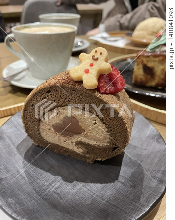 Soft roll cake with fluffy sponge layers and creamy filling spiraled inside, showcasing smooth texture, delicate shape, and sweet inviting appearance in close-up detail 140841093