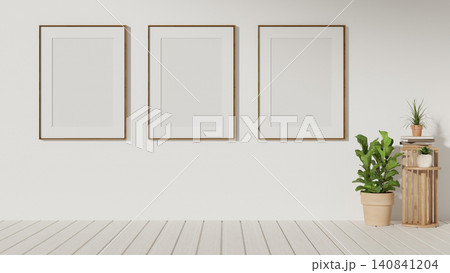 Minimalist triple wooden frames hanging on wall over potted plant and shelf in gallery presentation. Minimalist triple wooden frames hanging on wall over potted plant and shelf in gallery presentation. 140841204