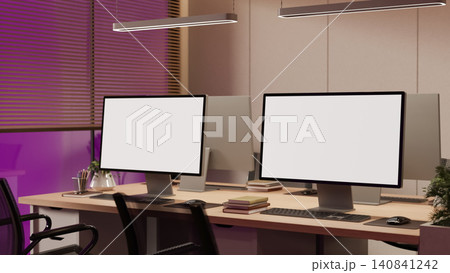 Modern office with desktop computer mockups and ambient evening lighting 140841242