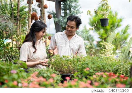 Asian man and woman couple enjoying flowers and plants together in a botanical garden greenhouse. 140841500