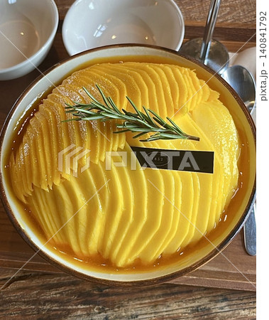 Refreshing mango bingsu with fluffy shaved ice, sweet mango chunks, and creamy condensed milk. A perfect Korean dessert for hot days, offering a delightful balance of fruity and creamy flavors! 140841792