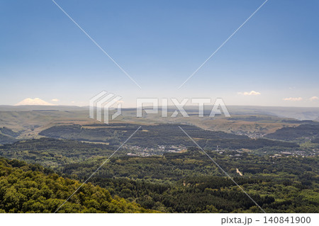 Panoramic view of the green valley and the snowy peak of Mount Elbrus on the horizon against the blue sky on a sunny clear morning in Kislovodsk Stavropol territory, Russia 140841900