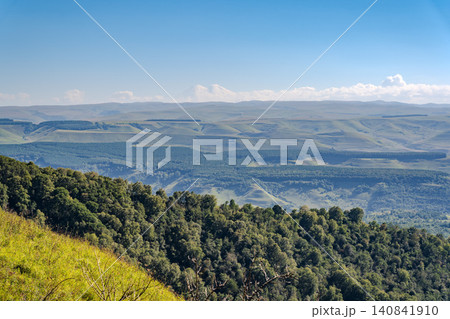 Panoramic view of the green valley and the snowy peak of Mount Elbrus on the horizon against the blue sky on a sunny clear morning in Kislovodsk Stavropol territory, Russia Panoramic view of the green valley and the snowy peak of Mount Elbrus on the horizon against the blue sky on a sunny clear morning in Kislovodsk Stavropol territory, Russia 140841910