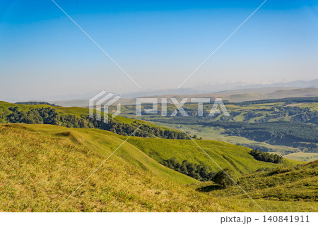 Layers of green mountains and hills in the haze during sunset. Panoramic View of Green hills and Meadow. Layers of green mountains and hills in the haze during sunset. Panoramic View of Green hills and Meadow. 140841911
