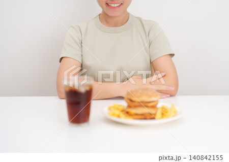 happy woman with Juicy beef burger with melted cheddar cheese, potato chips and carbonated Soft drinks. Unhealthy, High calorie, Fast food craving, Obesity, diet, weight loss, junk food and lifestyle happy woman with Juicy beef burger with melted cheddar cheese, potato chips and carbonated Soft drinks. Unhealthy, High calorie, Fast food craving, Obesity, diet, weight loss, junk food and lifestyle 140842155