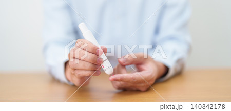 Hand using lancet pen on finger with Blood drop glucose testing or Diabetes checking by digital blood glucose meter. blood sugar level, Diabetes Day, Glycemia, Hypoglycemia, Hyperglycemia and insulin Hand using lancet pen on finger with Blood drop glucose testing or Diabetes checking by digital blood glucose meter. blood sugar level, Diabetes Day, Glycemia, Hypoglycemia, Hyperglycemia and insulin 140842178