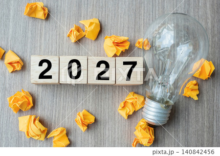 2027 text wood cube blocks and crumbled paper with lightbulb on wooden table background. New Year New Ideas, Creative, Innovation, Imagination, inspiration, Resolution, Strategy and goal concept 2027 text wood cube blocks and crumbled paper with lightbulb on wooden table background. New Year New Ideas, Creative, Innovation, Imagination, inspiration, Resolution, Strategy and goal concept 140842456