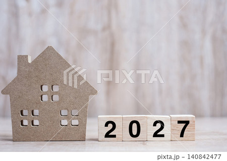 2027 Happy New Year with house model on table wooden background. Banking, real estate, investment, financial, savings and New Year Resolution concepts 2027 Happy New Year with house model on table wooden background. Banking, real estate, investment, financial, savings and New Year Resolution concepts 140842477