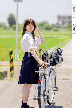 自転車を押しながら振り返る女子高校生の通学シーン 自転車を押しながら振り返る女子高校生の通学シーン 140842855
