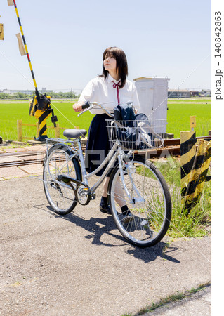 田園の踏切で自転車を押す女子高校生 田園の踏切で自転車を押す女子高校生 140842863