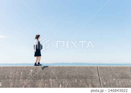 青空の海辺を歩く女子高校生と広がるコピースペース 青空の海辺を歩く女子高校生と広がるコピースペース 140843022