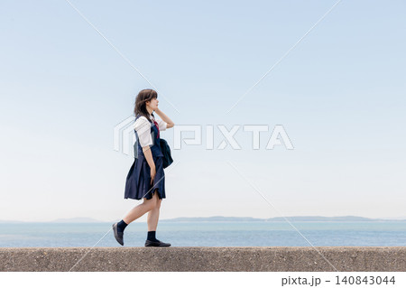 海辺を歩きながら通話する女子高校生 海辺を歩きながら通話する女子高校生 140843044