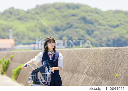 海辺の通学路で自転車を押す女子高校生のポートレート 140843063